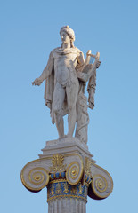 Apollo statue with his face illuminated by sun rays on blue sky background