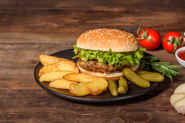 Tasty grilled homemade burger with beef, tomato, cheese, cucumber and lettuce