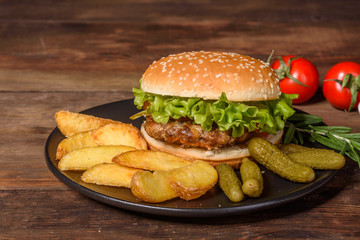 Tasty grilled homemade burger with beef, tomato, cheese, cucumber and lettuce