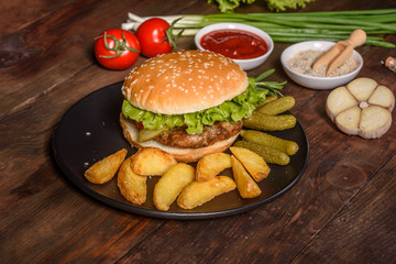 Tasty grilled homemade burger with beef, tomato, cheese, cucumber and lettuce