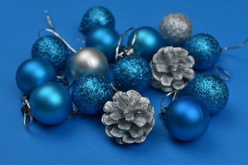 New Year's blue and silver balls and cones on a blue background. Place for an inscription. Card. Christmas. 2020 color. The trend of the year.
