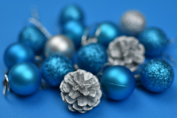 New Year's blue and silver balls and cones on a blue background. Place for an inscription. Card. Christmas. 2020 color. The trend of the year. .Blurred background.