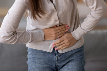 Close up of sick woman suffer from stomach ache