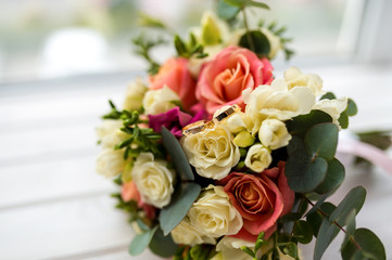 beautiful tender wedding bouquet of cream and pink roses and eustoma flowers in blurred background. Wedding details concept.