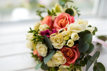 beautiful tender wedding bouquet of cream and pink roses and eustoma flowers in blurred background. Wedding details concept.