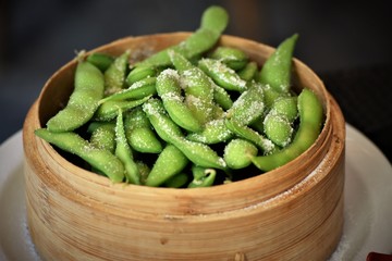 salted Edamame in a wooden baske