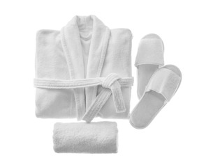 Clean folded bathrobe, slippers and towel isolated on white, top view