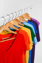 Colorful clothes on hangers against white background