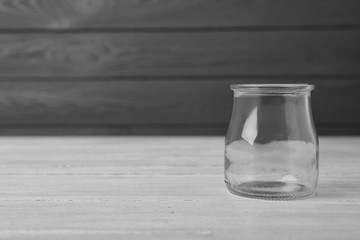 Empty glass jar on white wooden table, space for text