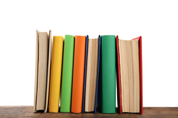 Colorful books on wooden table against white background