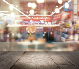 Empty wooden surface and blurred view of shopping mall. Space for design