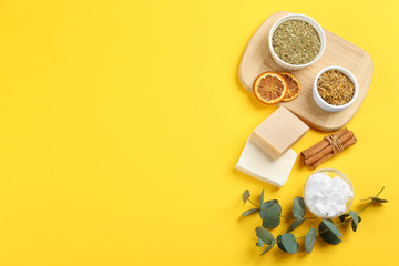 Flat lay composition with natural handmade soap and ingredients on yellow background. Space for text