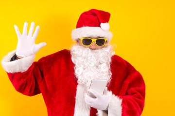 Santa Claus pointing the mobile phone with surprise gesture