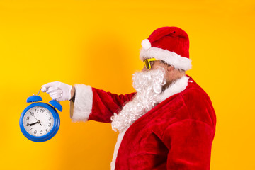 Santa Claus holding the alarm clock in a hand, Christmas comes