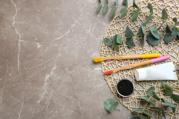 Flat lay composition with bamboo toothbrushes on grey marble table. Space for text