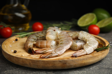 Fresh raw shrimps with rosemary on wooden board