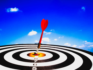 Fototapeta na wymiar Dart Board Isolated on blue sky and clouds background, Setting challenging business goals And ready to achieve the goal concept