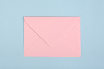 Pink paper envelope composition on blue background.