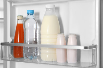 Obraz na płótnie Canvas Different bottles in basket of modern refrigerator