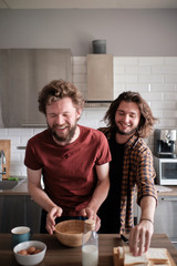 Gay couple goofying at the kitchen while making breakfast