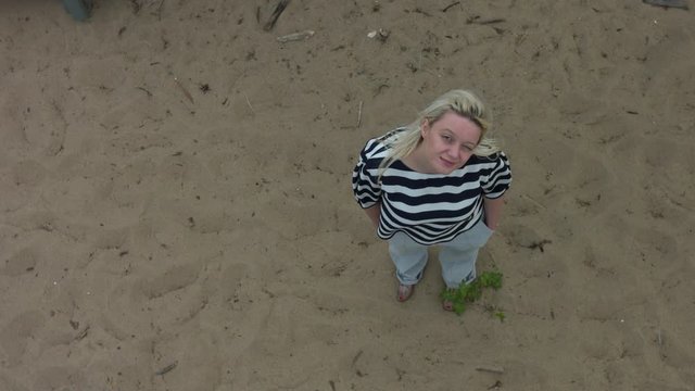 Bird's eye view of a woman in zebra shirt looking up in the sky.