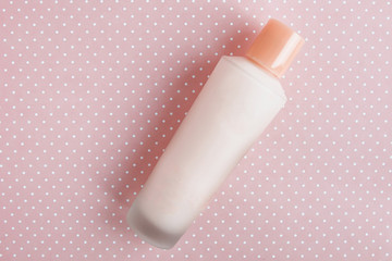 minimalistic bottle with cosmetics without inscriptions on a pink background 