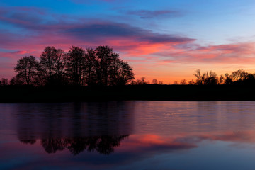 Obraz na płótnie Canvas Sunset at czech countryside lake. Dramatic clouds.