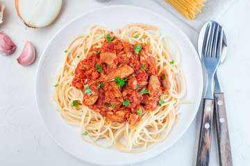 Spaghetti with tuna and tomato basil sauce garnished with parsley, horizontal, top view