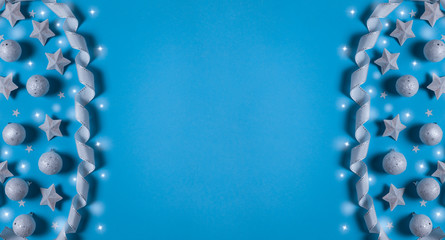 Christmas banner with Xmas decoration, shiny balls, tape and stars on blue background with copy space.