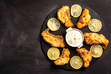 Exposition of cooked fish on black plate and wooden table, very tasty food.
