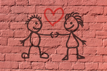 Two lovers hold hands. Primitive drawing on a brick wall