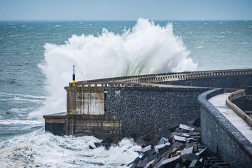 powerful waves breaking at breakwater during a storm