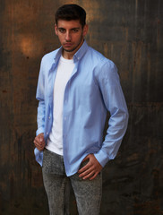 Obraz premium boy in blue striped shirt and gray jeans with gray background
