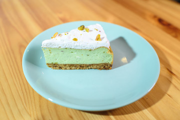 Bright and tasty pistachio cake on a large light wooden table