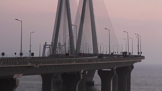 Real time Closeup shot of vehicles passing by on Mumbai's famous Bandra Worli Sea Link (BWSL) Bridge during sunset. 5726.