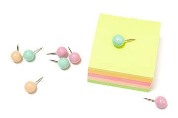 Paper notes with pink, blue and beige pins one on top for work planning isolated white background