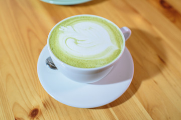 Matcha latte close-up on a large bright wooden table