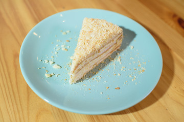 Slice of Napoleon cake on a large light wooden table