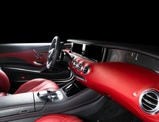 Fototapeta na wymiar Red luxury modern car Interior with steering wheel, shift lever and dashboard. Clipping path. Detail of modern car interior. Automatic gear stick. Part of leather seats with stitching in expensive car