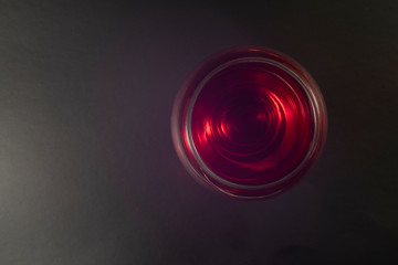 Glass of red wine on a black background. Top view