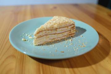 Slice of Napoleon cake on a large light wooden table