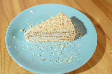 Slice of Napoleon cake on a large light wooden table