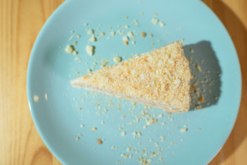 Slice of Napoleon cake on a large light wooden table