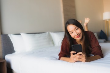 Portrait beautiful young asian women using mobile phone on bed