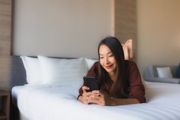 Portrait beautiful young asian women using mobile phone on bed