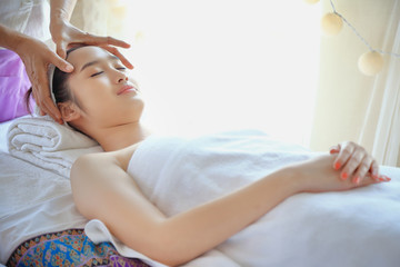 Young woman receiving head massage at health spa