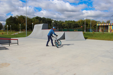 man in a helmet rides a bmx bike in a skate park