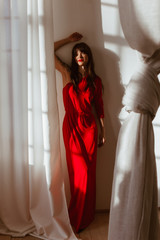 Beautiful young woman in long red dress