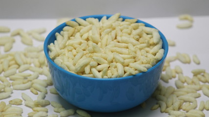 Puffed rice on the blue bowl with white background