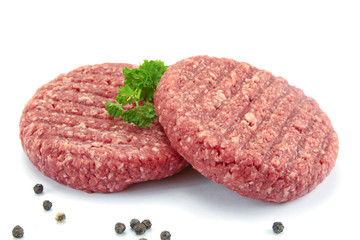 two minced steaks of raw beef on a white background